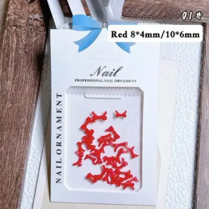 Bow tie nail charms styled in red, white and black on manicure display