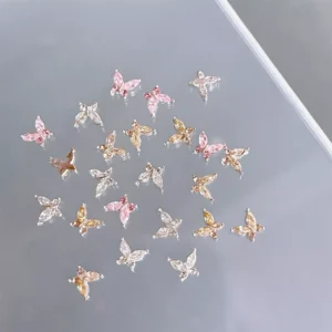 Crystal butterfly nail charms displayed on clear acrylic surface