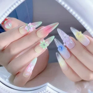 Dual hand manicure featuring colorful resin flower charms with rhinestones