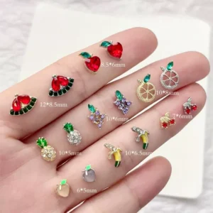 Assorted zircon fruit nail charms in different sizes on hand