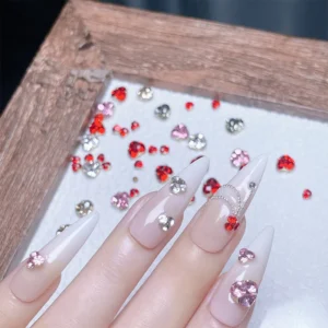 3D rhinestone nail decorations in red and pink applied on ombre nails