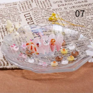 Round animal face nail decorations displayed in a glass tray