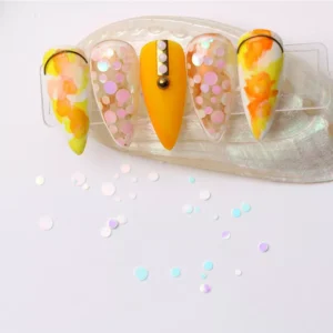 Close-up of orange and floral nail art with scattered sequins