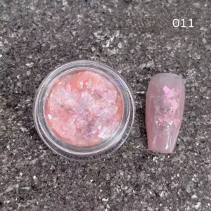 Coral-pink iridescent nail sequins with shimmer effect on neutral polish