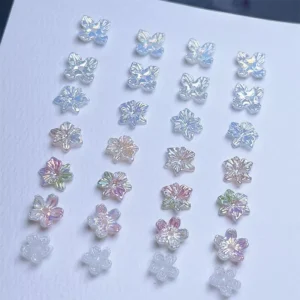 Aurora flower nail decorations sorted in color rows under soft light
