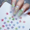 Aurora Resin Nail Charms - Sparkle Starfish, Stars & Letter 5 Hand showing pastel nail art decorated with Aurora Resin Nail Charms in starfish, star, and letter shapes