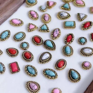Baroque-style gemstone nail charms in red, turquoise, pink, and white