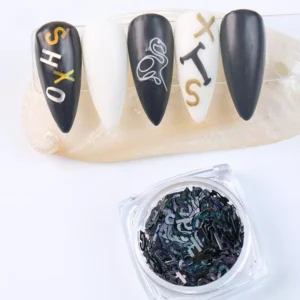 Black letter nail sequins in jar and on matte nail design