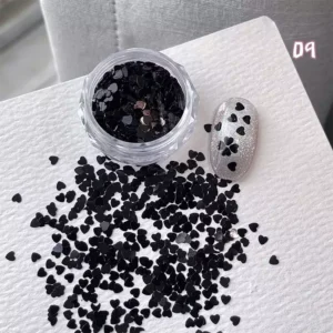Jar of black heart nail glitter with matching heart design on glitter nail tip