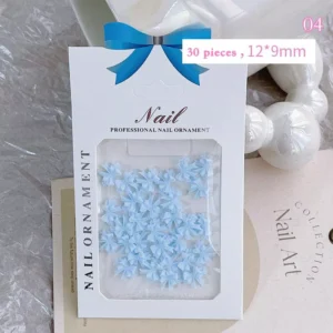 Sky blue resin nail bow charms in a clear retail package