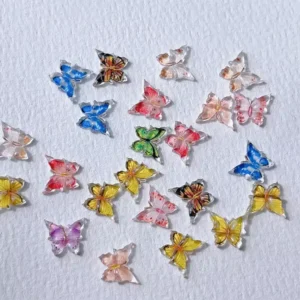 Colorful flat butterfly nail charms in primary tones – red, yellow, green, blue