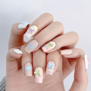 Full hand view of pastel bow nail charms in casual wear context