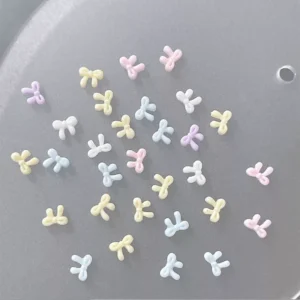 Mini pastel bows in cartoonish style with glossy surface spread on display tray