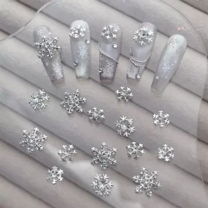 Christmas nail charms laid out with matching silver snowflake designs