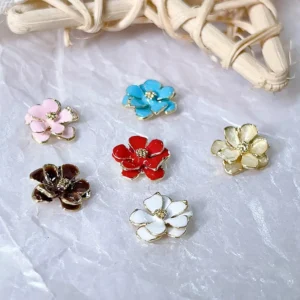 Assorted enamel-coated metal flower nail charms in pastel and bold colors