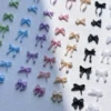 Colorful bow nail charms in pastel shades on white background