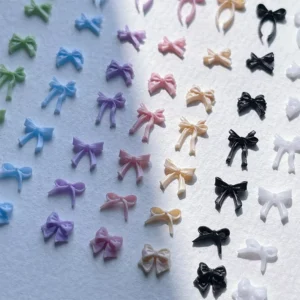 Colorful bow nail charms in pastel shades on white background