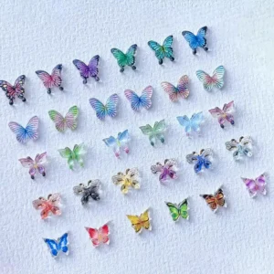 Assorted colorful butterfly nail charms on white background – showcasing 3D styles and iridescent finishes