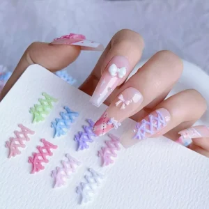 Pastel lace-up resin charms held near finished nail designs