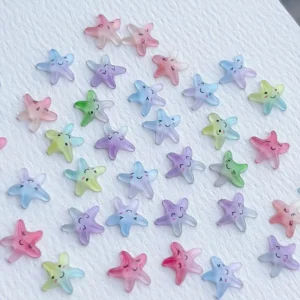 Mixed pastel kawaii starfish nail charms scattered on textured surface