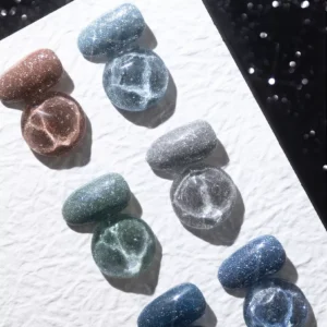 Silver, teal, and blue glitter polish swatches with light reflection