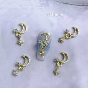 Crescent moon gold nail charms with star accents on light background