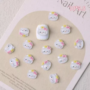 White cartoon cat head nail charms with pink bows and yellow crowns