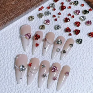 Mixed color crystal cluster nail charms displayed with beige nail tips