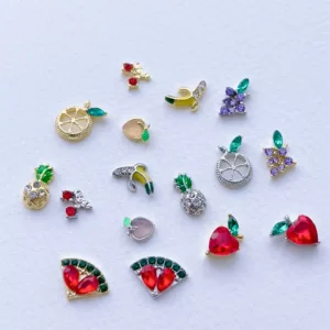 Full-hand view of nails decorated with sparkling crystal fruit nail charms