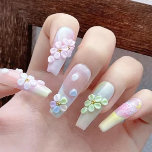 Five nails decorated with resin flowers and gold beads