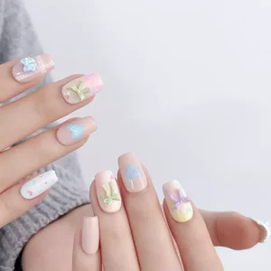 Nail art featuring colorful bow nail charms on pastel base