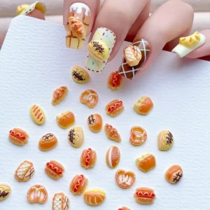 Hand displaying Cartoon Bread Nail Charms with detailed bakery motifs