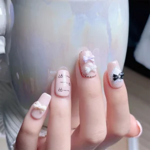 Manicure featuring full set of nails with pastel bow charms, holding pearlescent ceramic mug
