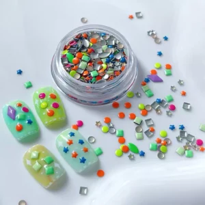 Assorted candy-color nail embellishments with nail tips and glitter jars
