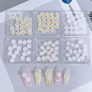3D daisy flower nail charms in soft white and yellow, displayed with nail design ideas