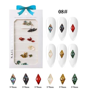 Diamond-cut resin nail decorations in bold gemstone tones including black, red, and opal shimmer