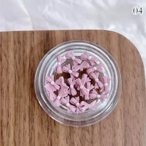 Dusty pink resin nail bows with pearl embellishments, semi-gloss texture