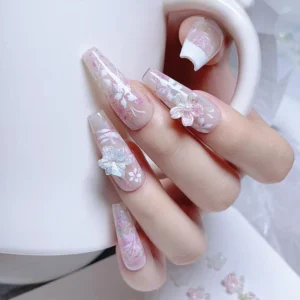 Elegant nail set with applied aurora blossom nail charms over pink floral base