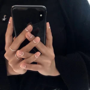 Minimalist nude nails decorated with pearl nail art accents