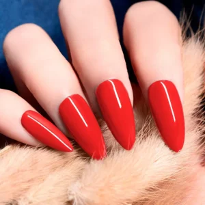 Bright fire-red gel polish nails on model hand with soft fur