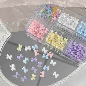 Flat-back pastel bow charms for nails in soft candy colors on mirror surface