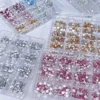 Flat Back Nail Rhinestones in pink, gold, and silver sorted in grid storage boxes