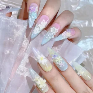 Close-up of long gradient nails decorated with iridescent floral embellishments