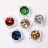 Foil flake nail set with red, green, silver, gold, and blue tones in clear containers