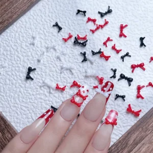 Mixed 3D bow tie charms scattered on textured surface with nail demo