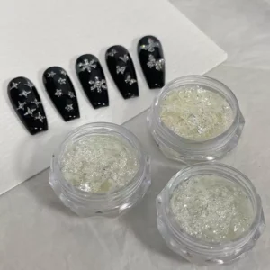 Iridescent diamond nail glitter flakes displayed beside black nail samples