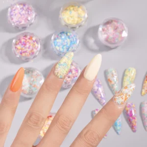 Hand model showing chameleon glitter nail flakes applied over pastel base
