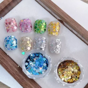Full set of glitter nail tips using Aurora holographic nail sequins in nine vivid shades with two open jars below