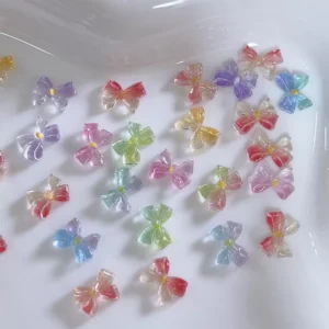 Jelly bow nail charms shown in scattered display across a white dish