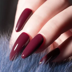 Manicured hand with long almond-shaped nails in wine red polish